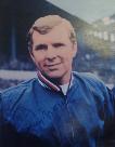 Bobby Moore in blue England tracksuit signed